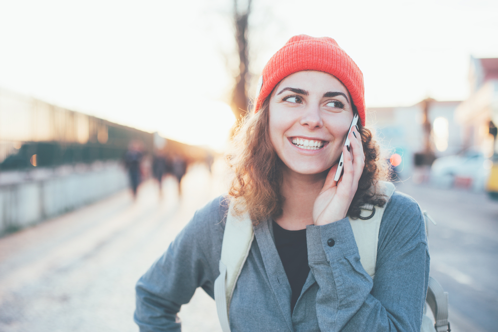 スマートフォンで通話しながら街を歩く女性